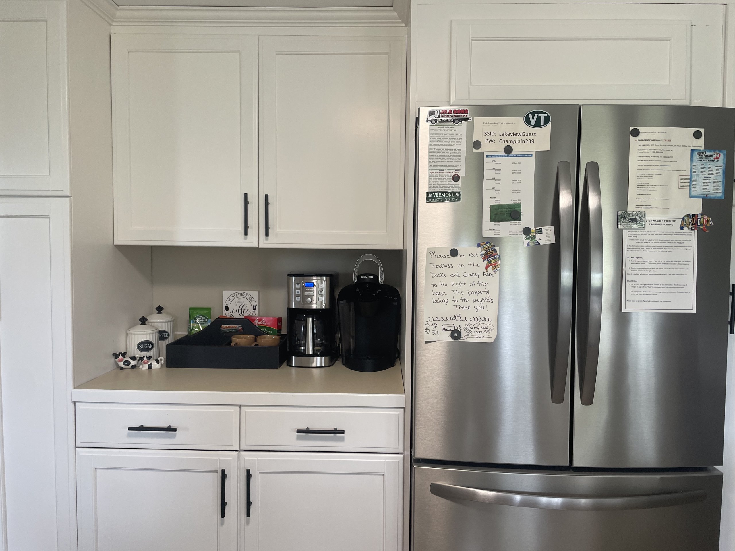 Coffee and tea supplies arranged next to the stainless steel refrigerator
