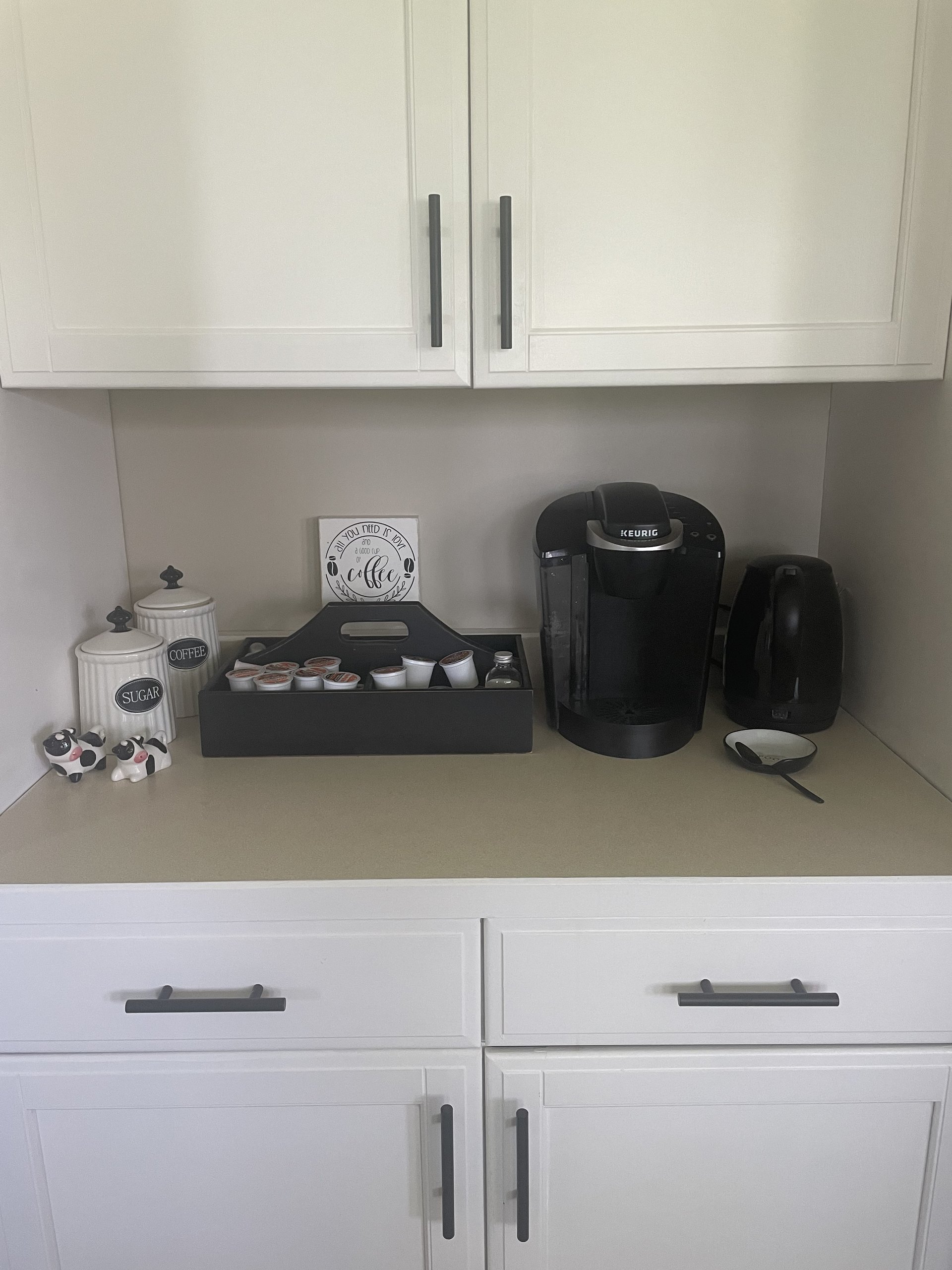 Coffee bar corner stocked with a Keurig, drip maker, and sugar canisters