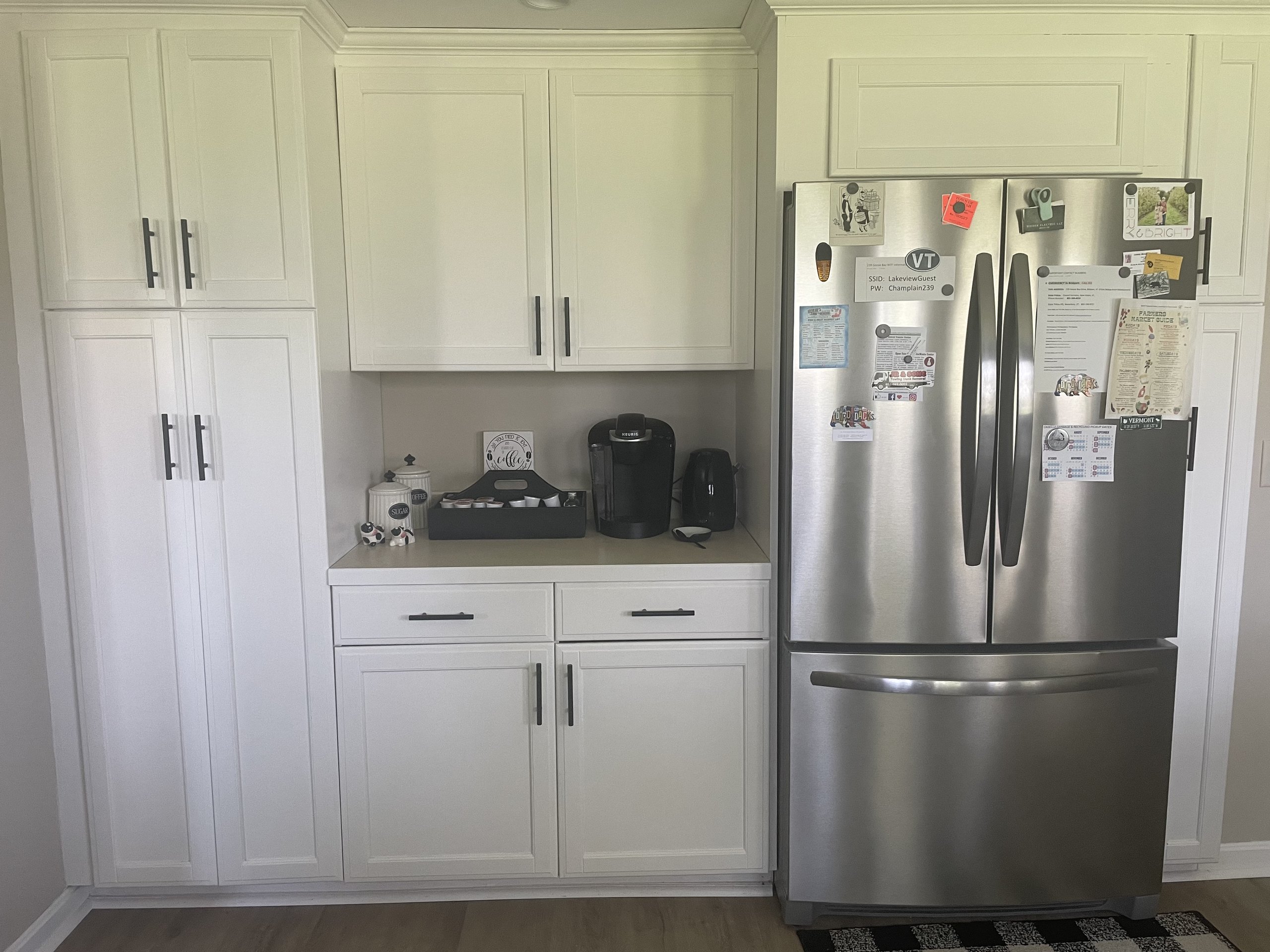 Coffee station tucked beside the stainless refrigerator with handy house notes
