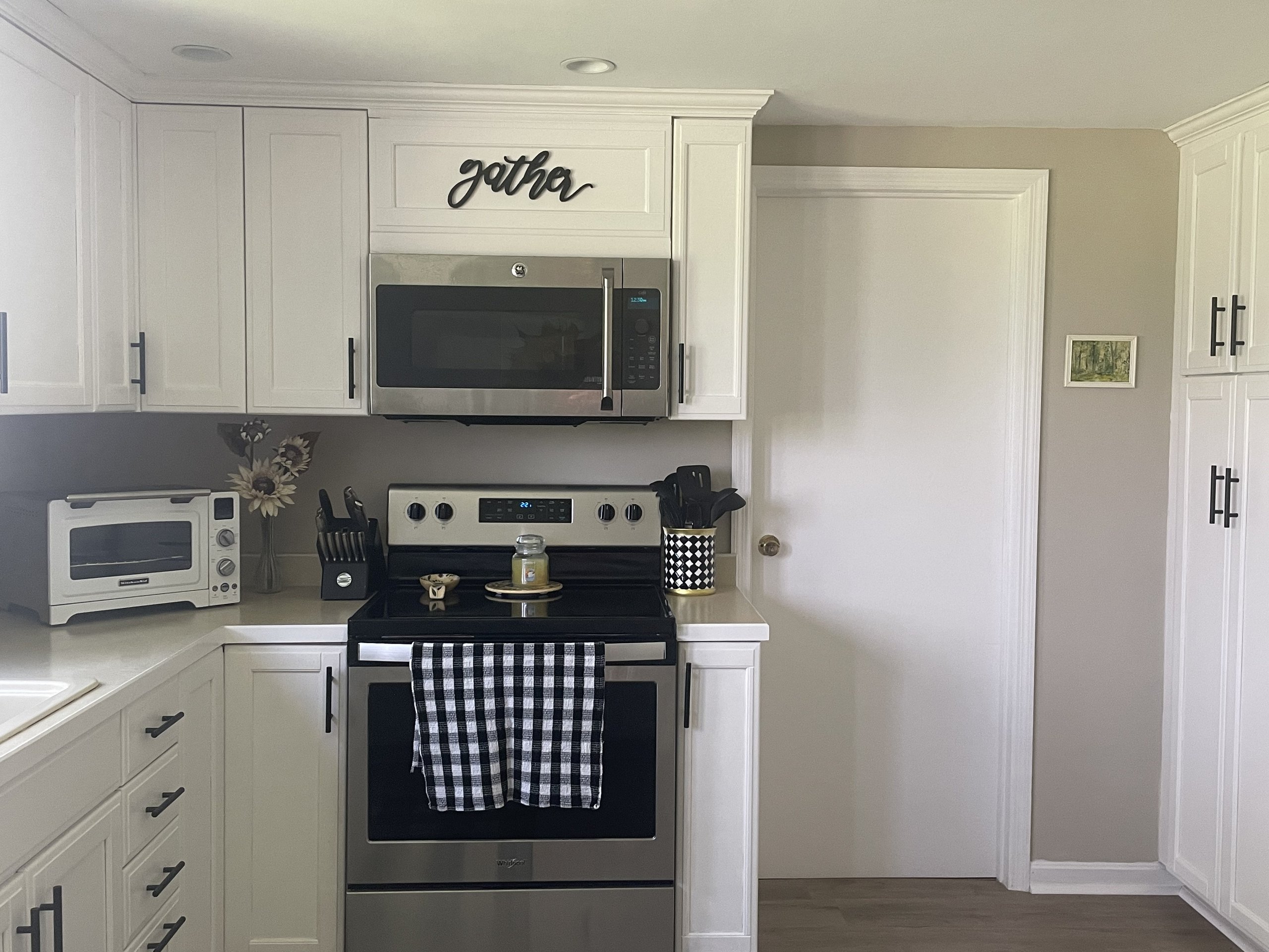 Stove and microwave nook beside the doorway leading toward the hallway
