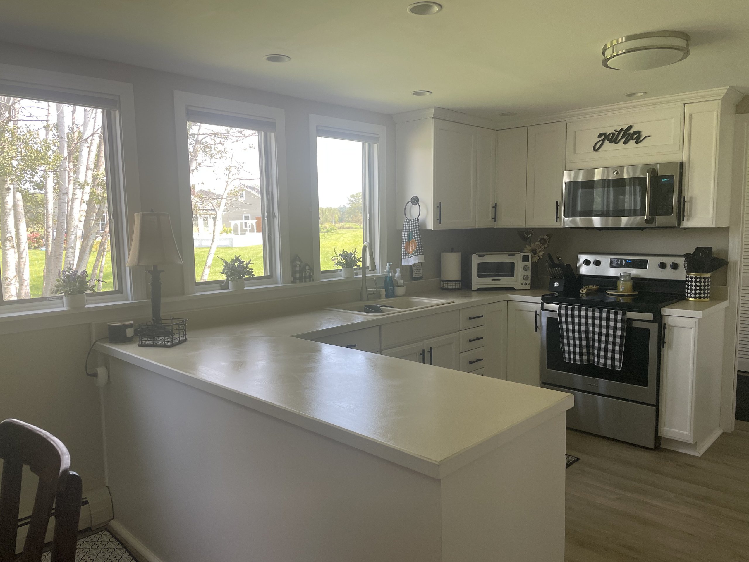 Kitchen viewed from the breakfast bar, framed by four garden-view windows