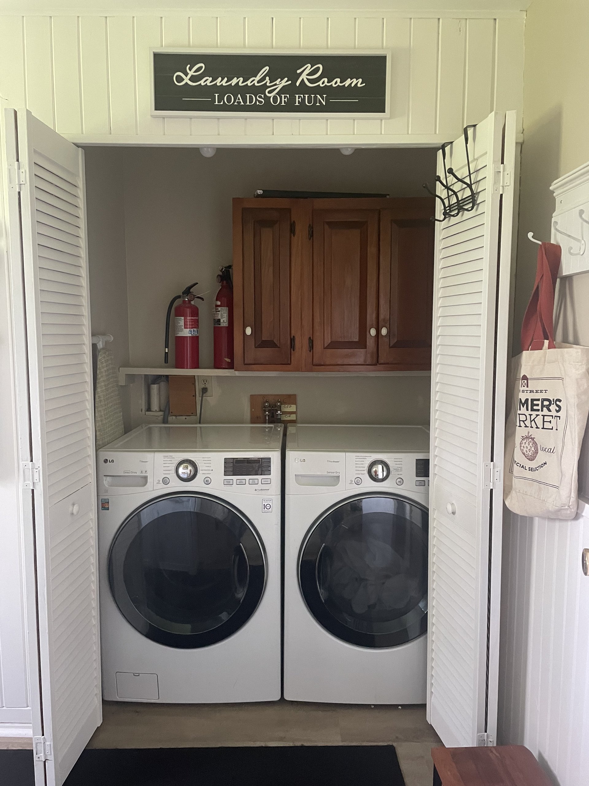 Stacked laundry closet with front-load washer and dryer behind louvered doors