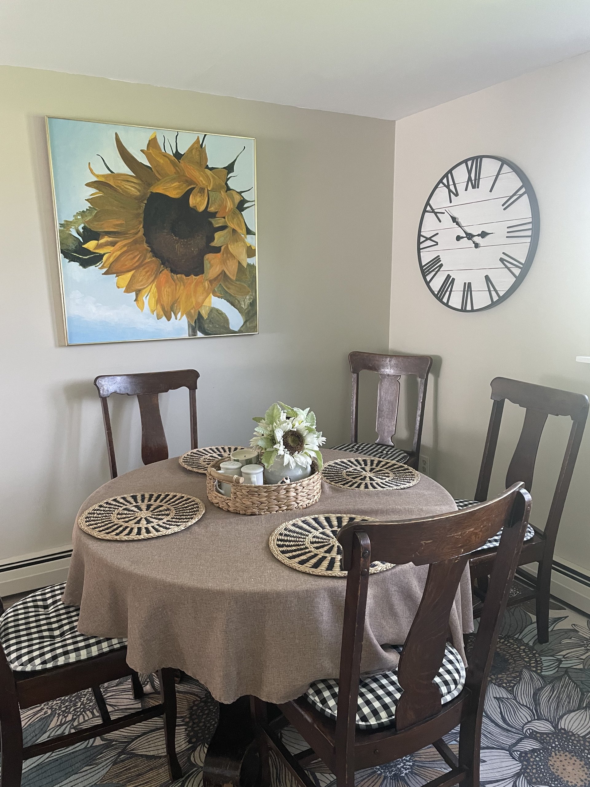 Cozy breakfast table with woven placemats and a large sunflower artwork