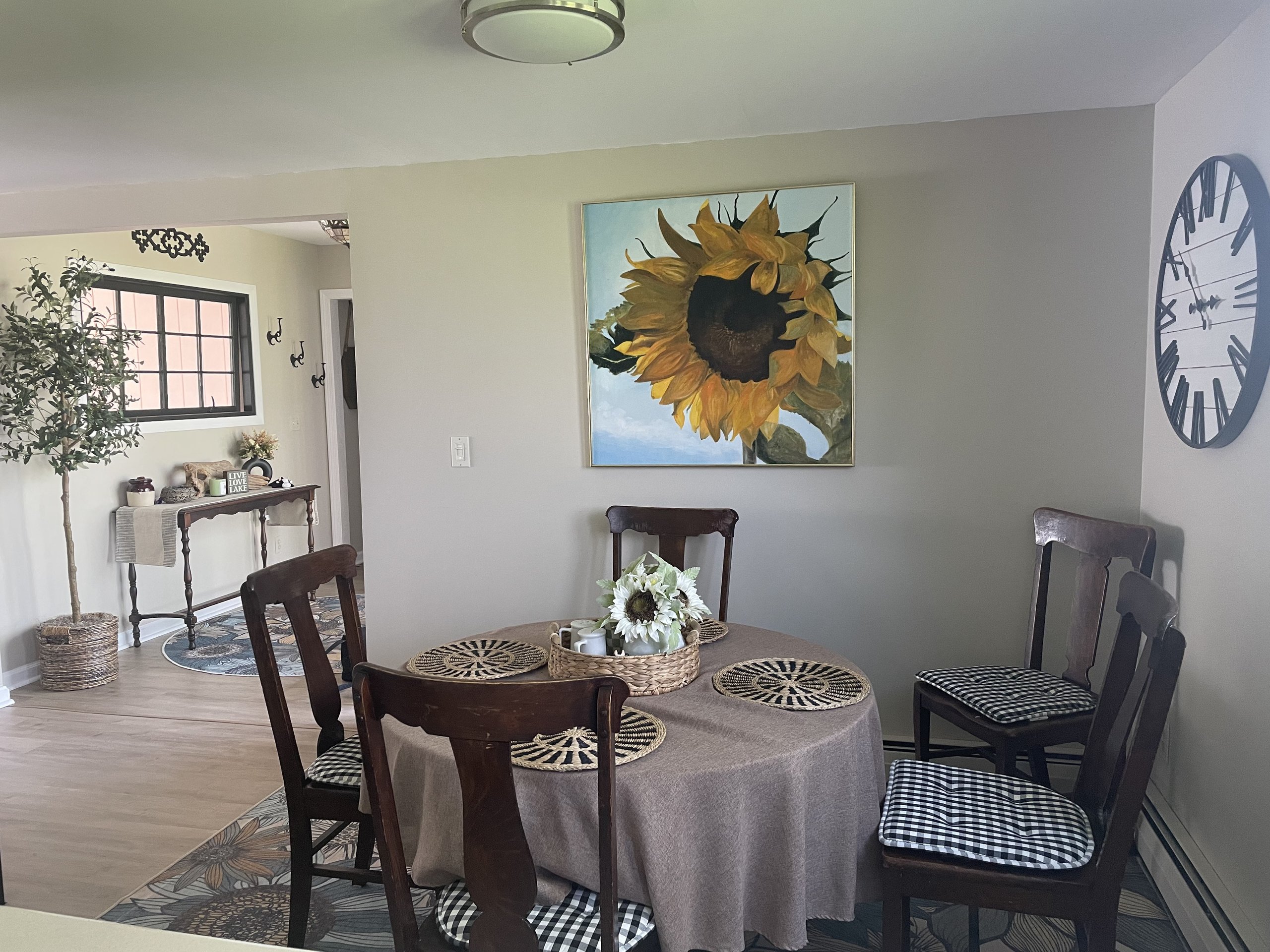 Dining corner featuring a faux olive tree and sunflower canvas artwork