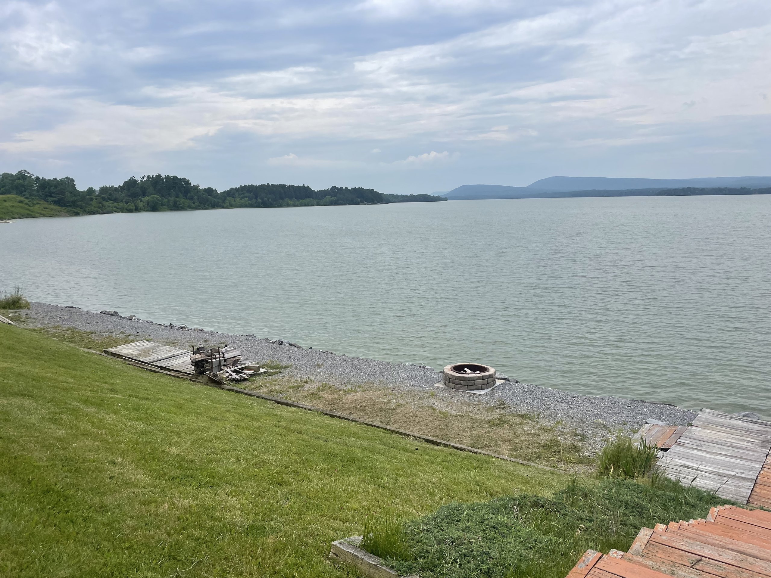 Fire pit and dock nestled along the gravel shoreline with mountains beyond