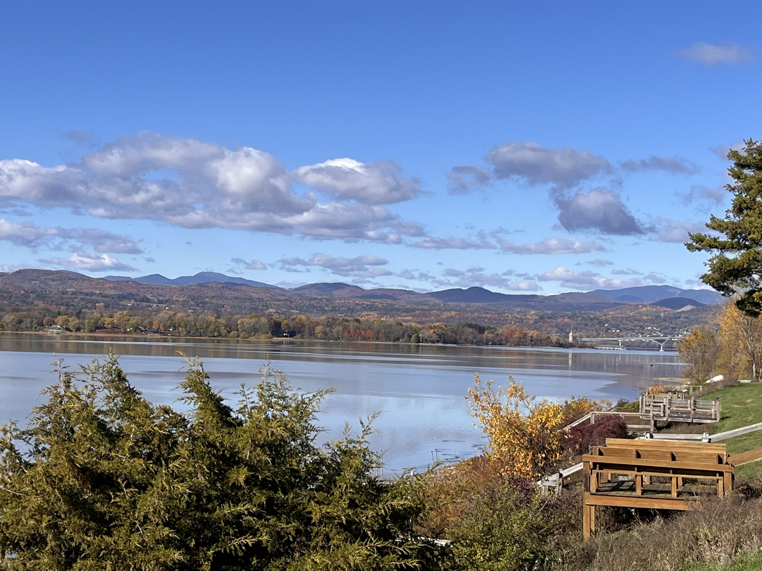 Autumn foliage colors the shoreline hills under a crisp blue sky