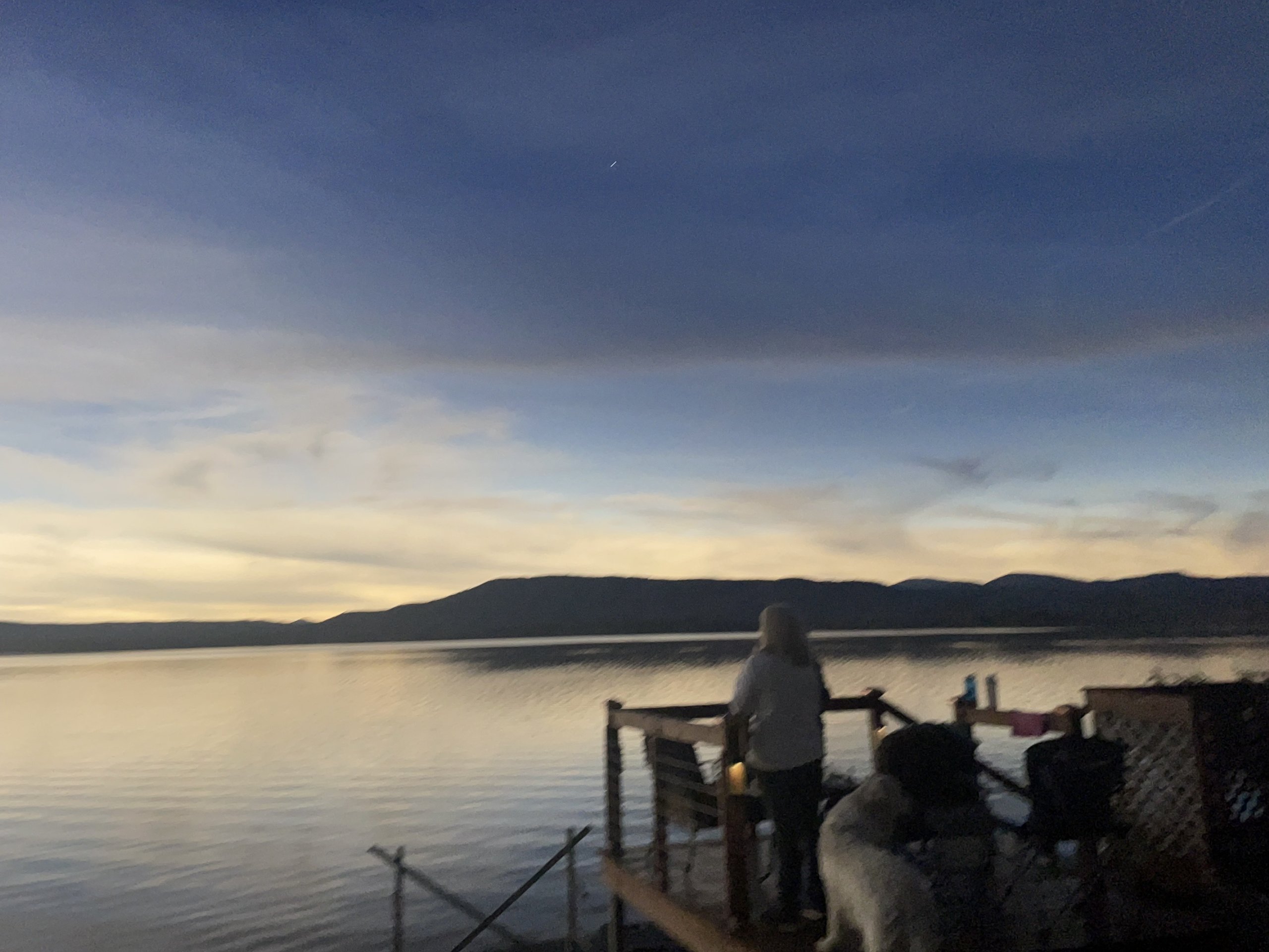 Family and dog take in the sunset view from the lakeside deck