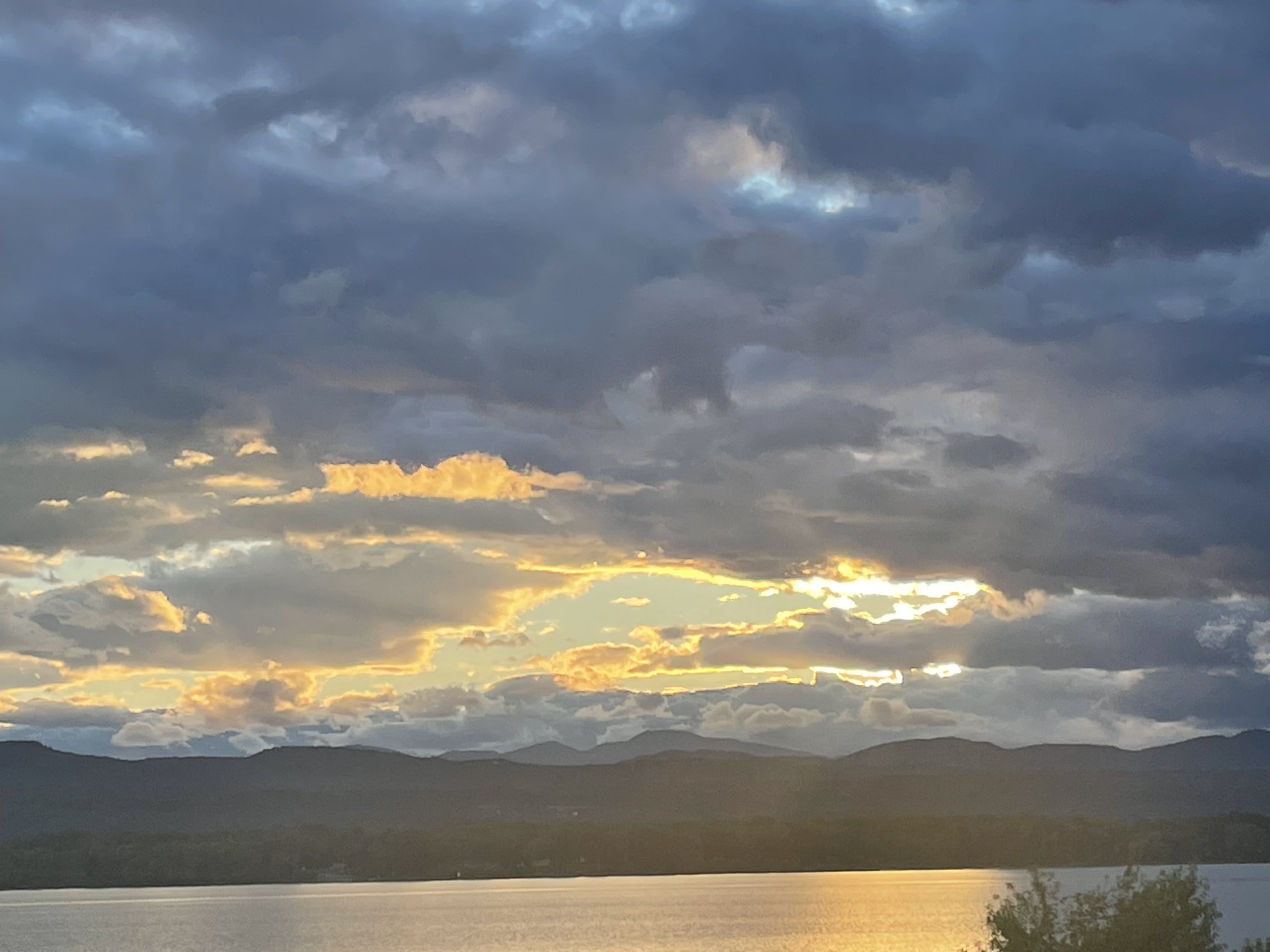 Streaks of orange and gold light up the sky above the mountain ridgeline