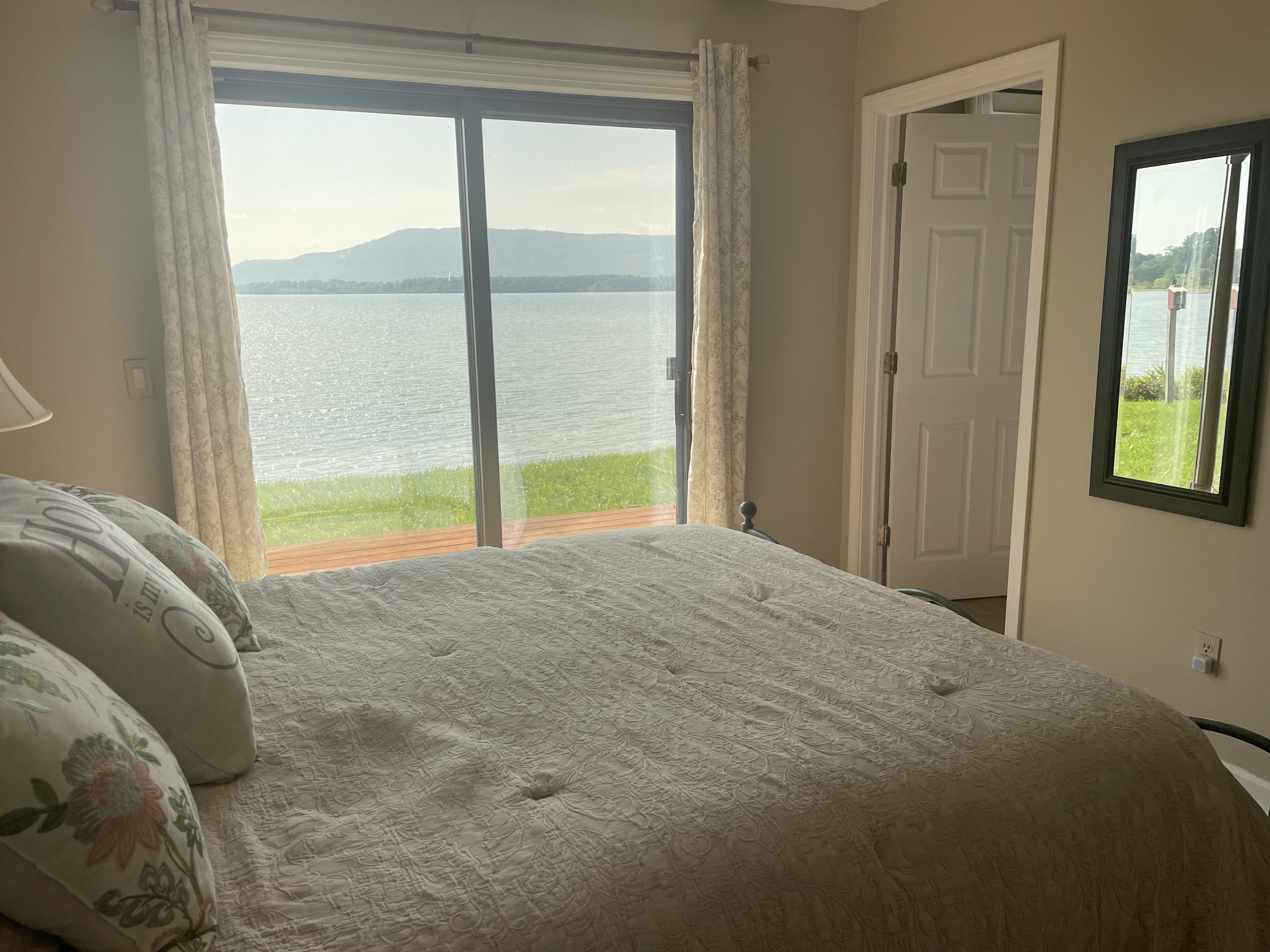 Bed footboard framed by a wide lake view and distant mountains